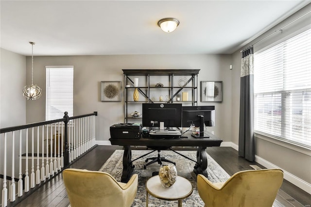 home office featuring dark hardwood / wood-style flooring and a notable chandelier