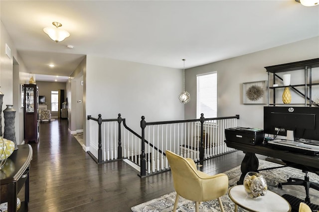 interior space with dark wood-type flooring, a notable chandelier, and a healthy amount of sunlight