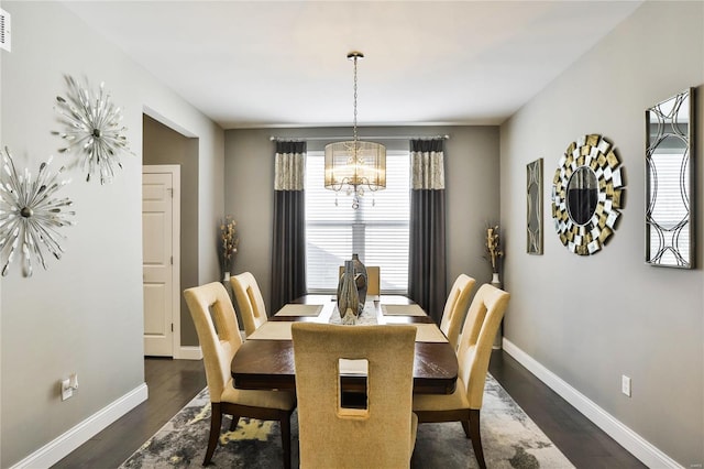 dining space with dark hardwood / wood-style flooring and a chandelier