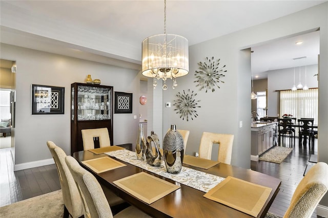 dining space featuring dark hardwood / wood-style flooring and an inviting chandelier