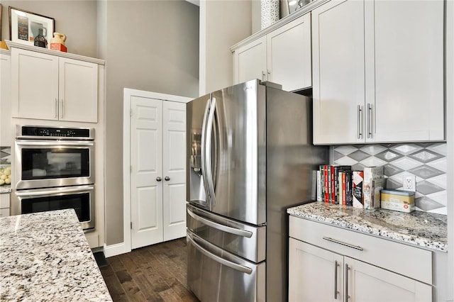 kitchen with stainless steel appliances, dark hardwood / wood-style floors, and white cabinets