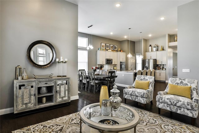 living room with dark hardwood / wood-style flooring, an inviting chandelier, and sink