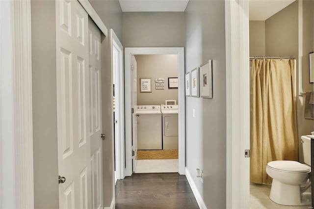 bathroom featuring a shower with shower curtain, vanity, washing machine and clothes dryer, toilet, and hardwood / wood-style flooring