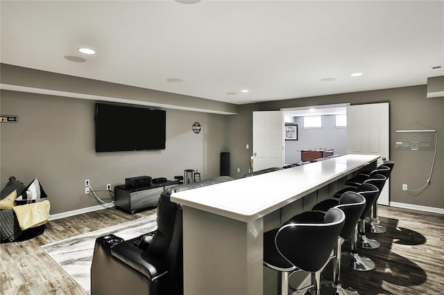 kitchen with a kitchen island, light hardwood / wood-style floors, and a breakfast bar