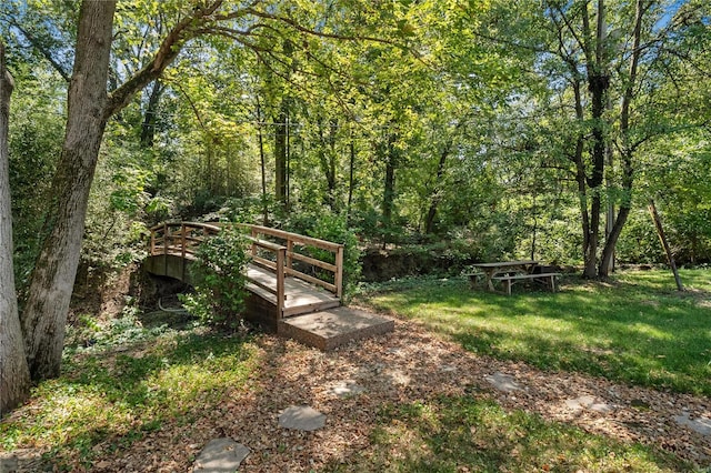 view of property's community featuring a lawn and a deck