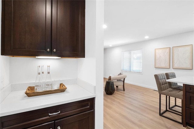 kitchen with dark brown cabinets and light hardwood / wood-style floors