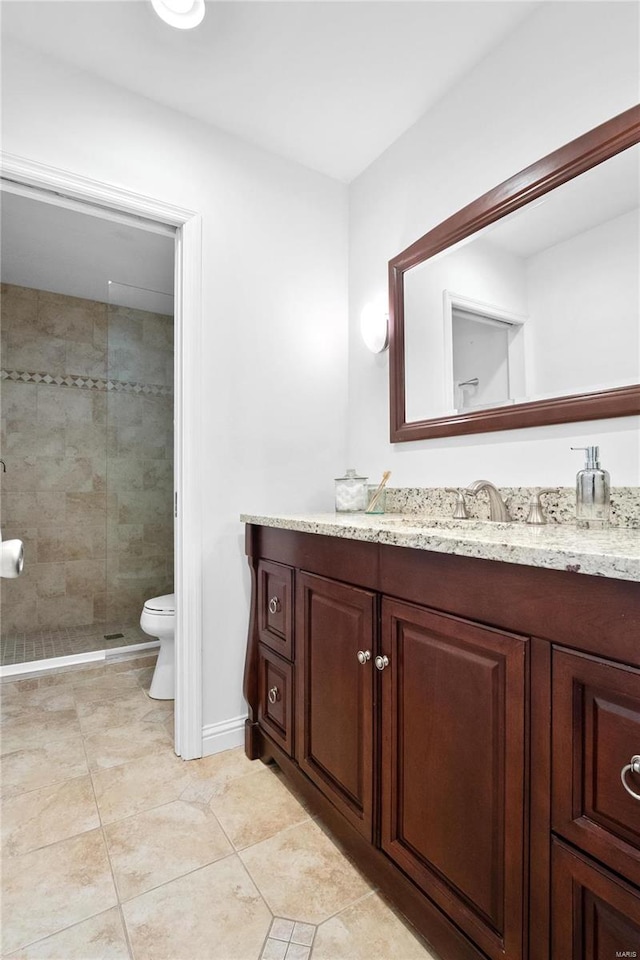 bathroom featuring vanity, toilet, a shower with shower door, and tile patterned floors