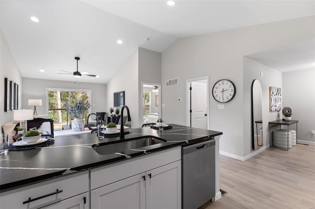 kitchen with light hardwood / wood-style flooring, dishwasher, sink, ceiling fan, and vaulted ceiling