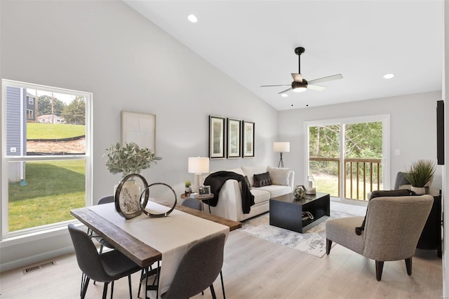 dining room with high vaulted ceiling, ceiling fan, and light hardwood / wood-style flooring