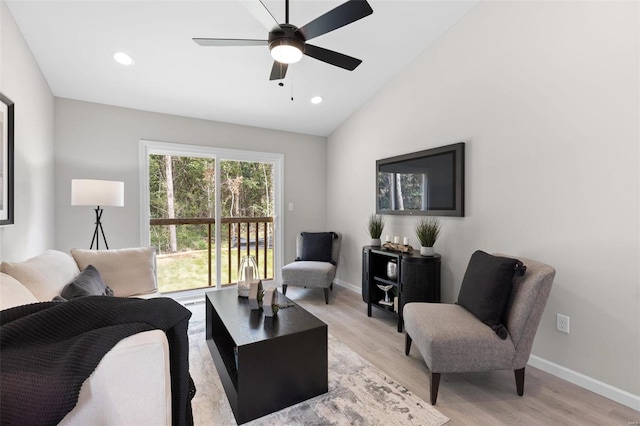 living room with light hardwood / wood-style flooring, ceiling fan, and vaulted ceiling