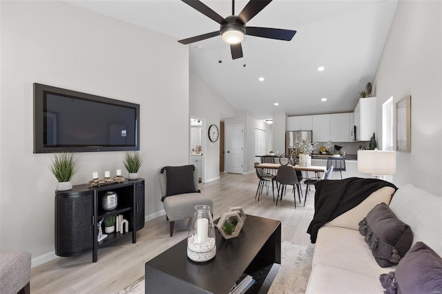 living room featuring ceiling fan, high vaulted ceiling, and light hardwood / wood-style floors