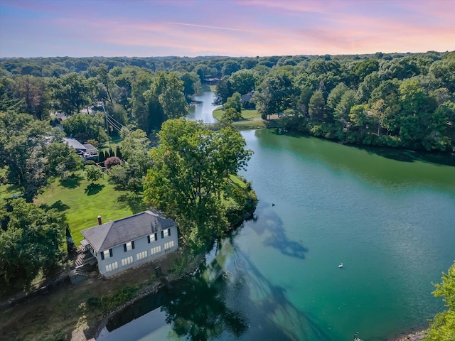 aerial view at dusk featuring a water view