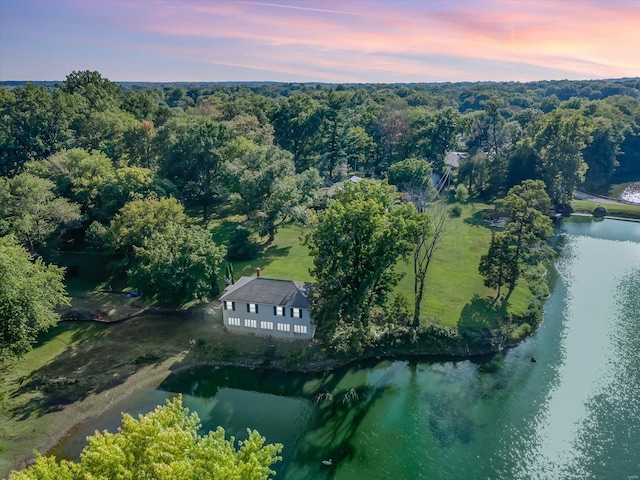 aerial view at dusk featuring a water view