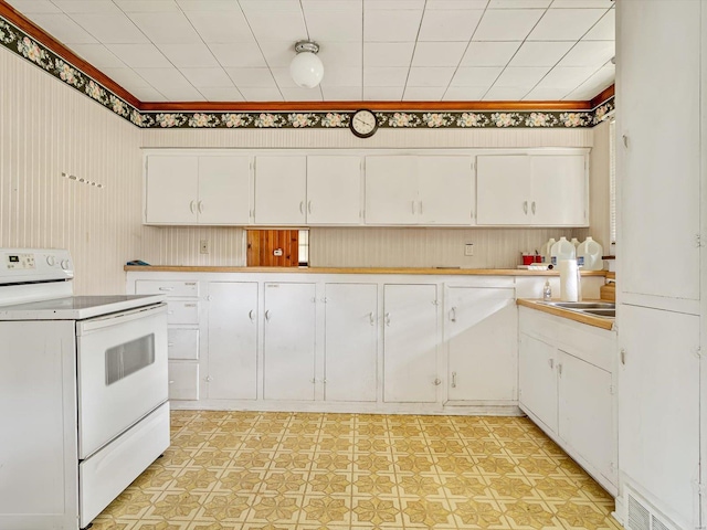 kitchen with sink, white range with electric cooktop, and white cabinets