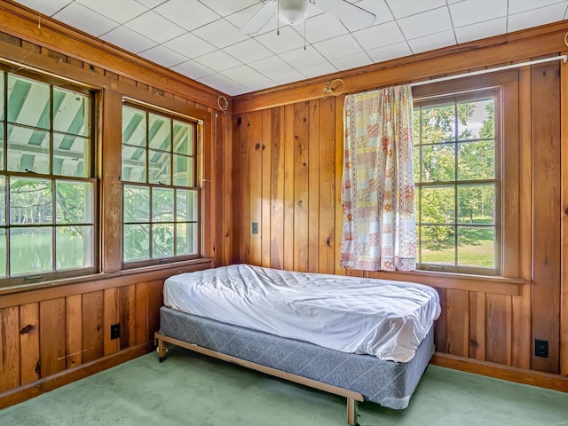 bedroom with multiple windows, wooden walls, and carpet