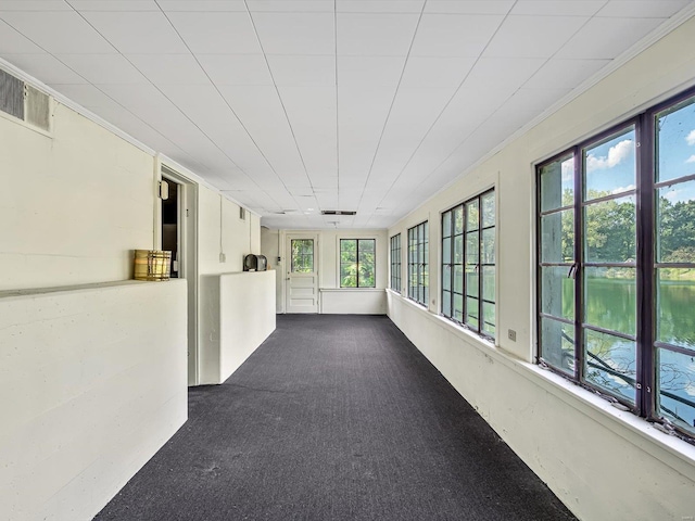 unfurnished sunroom featuring a water view