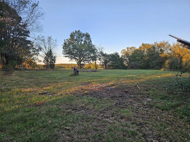 yard at dusk featuring a rural view