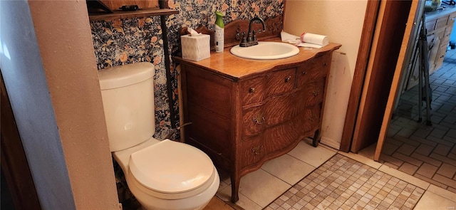 bathroom with tile patterned flooring, vanity, and toilet