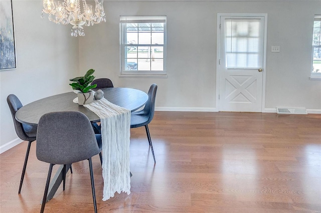 dining room with hardwood / wood-style floors and a notable chandelier