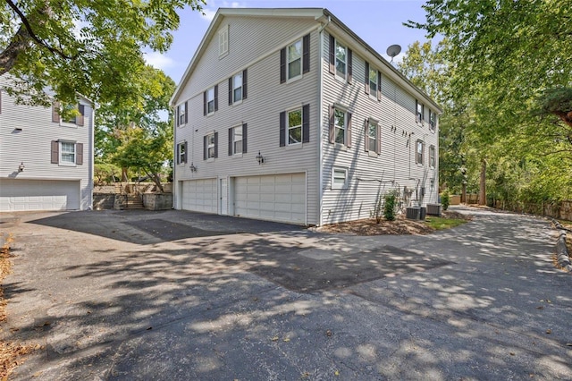 view of home's exterior with cooling unit and a garage