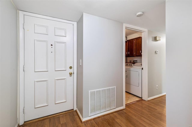 hall with light hardwood / wood-style flooring and washer and clothes dryer