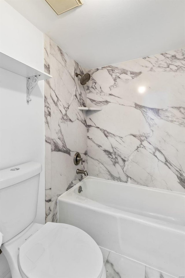 bathroom with tiled shower / bath combo and toilet