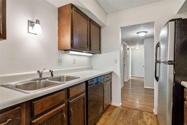 kitchen with stainless steel appliances, sink, and light hardwood / wood-style floors