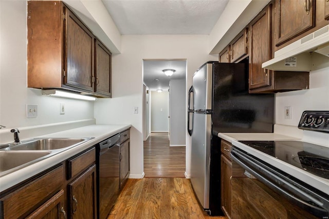 kitchen with dishwasher, sink, light hardwood / wood-style flooring, and white range with electric cooktop