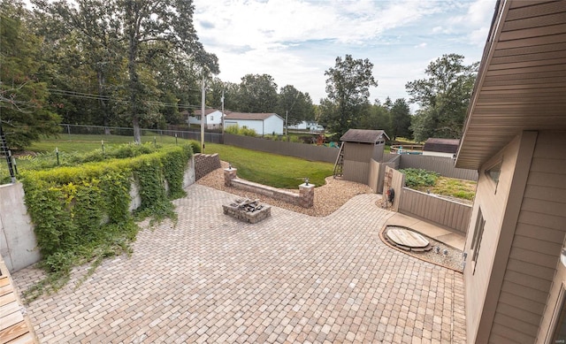 view of patio / terrace with an outdoor fire pit and a shed