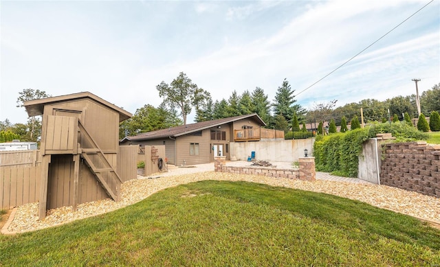 rear view of property with a patio area, a yard, and a storage unit