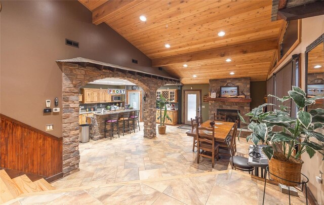 living room with beamed ceiling, high vaulted ceiling, wooden ceiling, and a fireplace