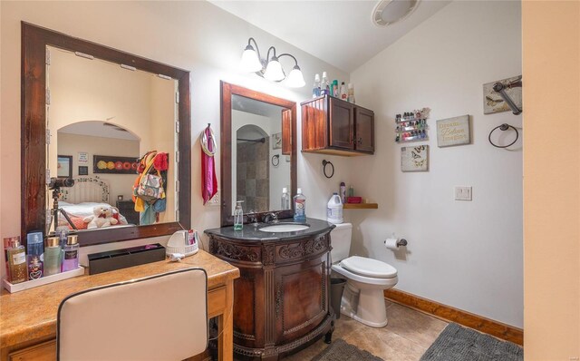 bathroom with lofted ceiling, vanity, toilet, and tile patterned flooring