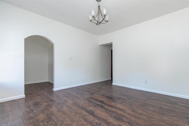 unfurnished room with dark wood-type flooring and a chandelier