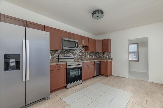 kitchen with sink, appliances with stainless steel finishes, light tile patterned floors, and tasteful backsplash