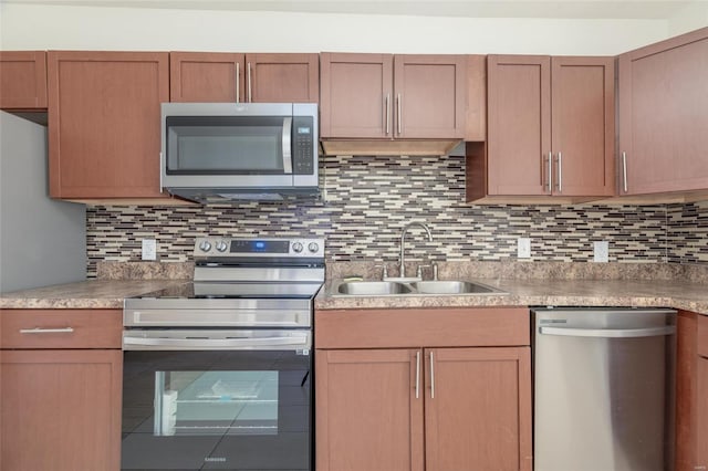 kitchen with appliances with stainless steel finishes, decorative backsplash, and sink