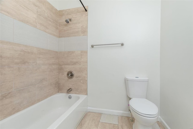 bathroom with tiled shower / bath, tile patterned flooring, and toilet