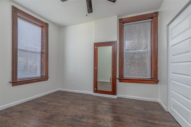 empty room with ceiling fan and dark hardwood / wood-style floors