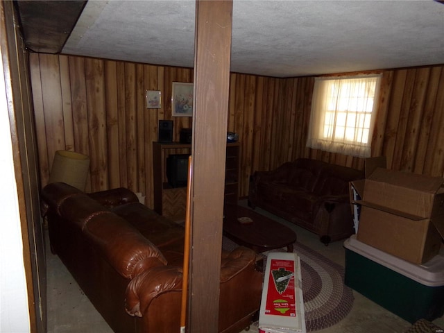 living room featuring a textured ceiling and wooden walls