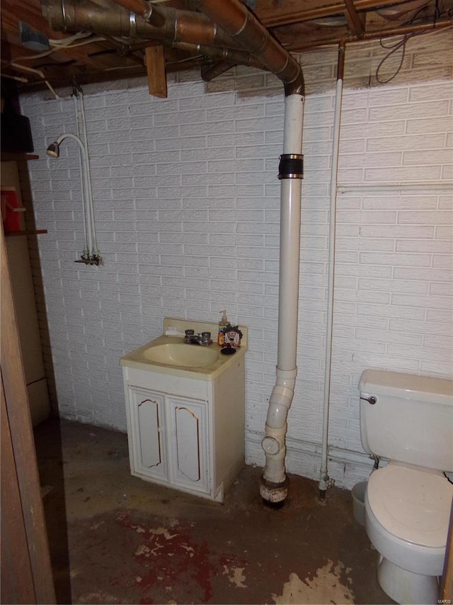 bathroom featuring toilet, sink, and concrete flooring