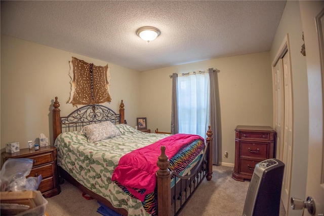 bedroom with a closet, a textured ceiling, and carpet