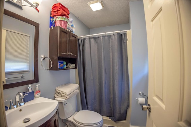 bathroom with a textured ceiling, vanity, toilet, and curtained shower