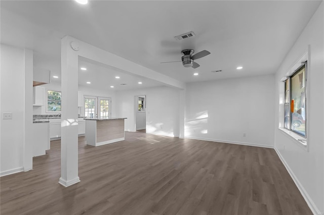 unfurnished living room with dark wood-type flooring and ceiling fan