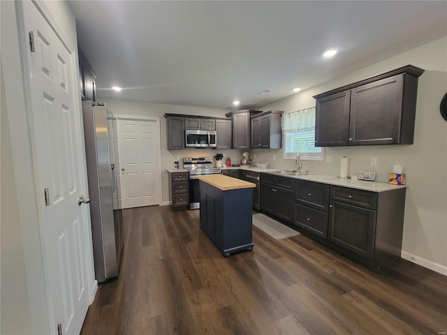 kitchen featuring wooden counters, a kitchen island, sink, dark hardwood / wood-style floors, and appliances with stainless steel finishes