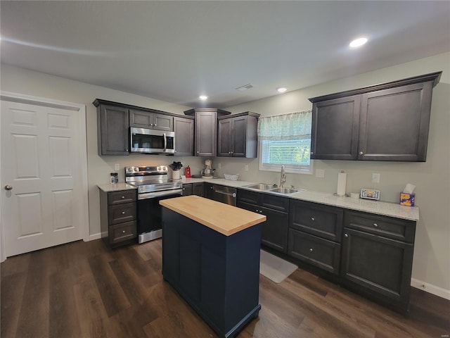 kitchen featuring dark wood-type flooring, appliances with stainless steel finishes, wood counters, and sink