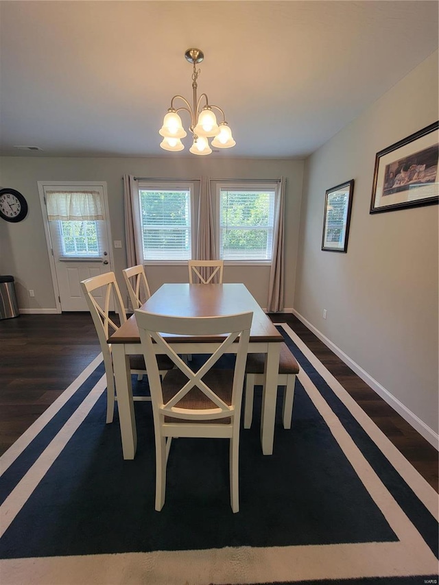 dining space featuring dark hardwood / wood-style flooring and a notable chandelier