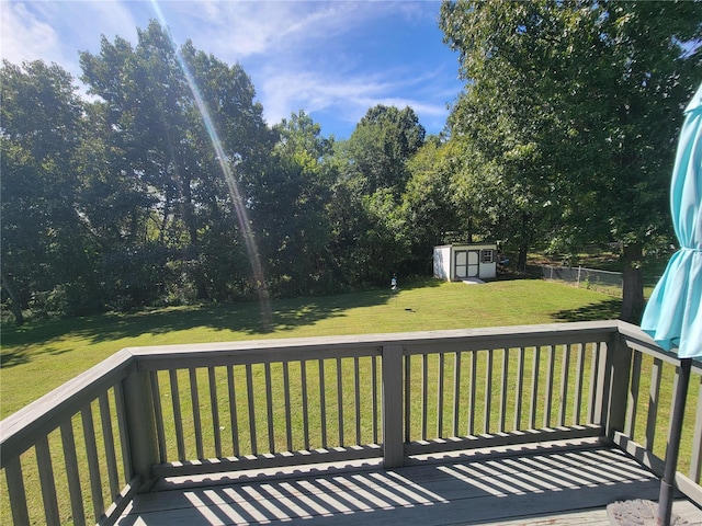 wooden deck with a storage shed and a lawn