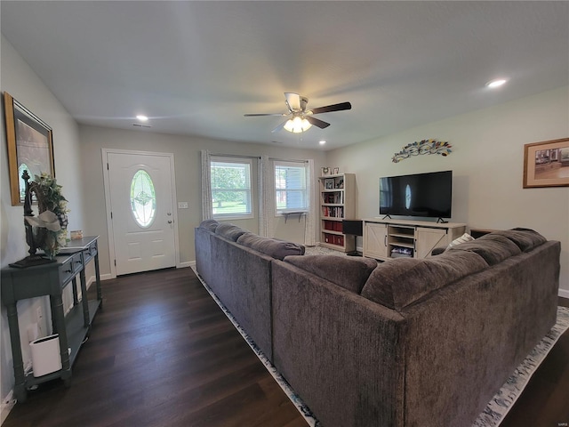 living room with dark wood-type flooring and ceiling fan