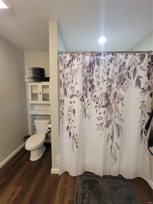 bathroom featuring hardwood / wood-style floors, toilet, and a shower with shower curtain