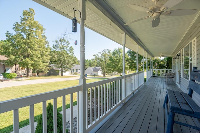 wooden deck with ceiling fan, a yard, and a porch