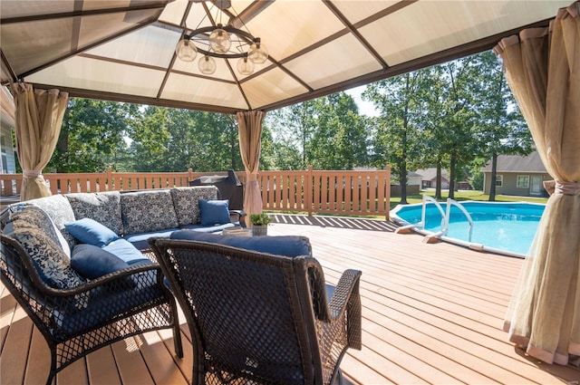 deck featuring a fenced in pool, outdoor lounge area, and a gazebo